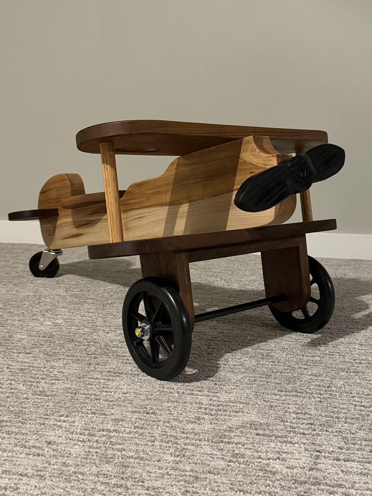 Large wooden biplane ride-on toy in walnut and cherry