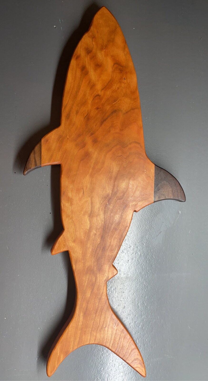 Cherry and walnut shark-shaped charcuterie board on wall